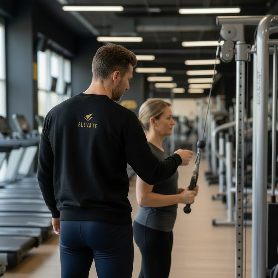 Entrenador de Elevate guiando a una socia durante una sesión en la sala del club